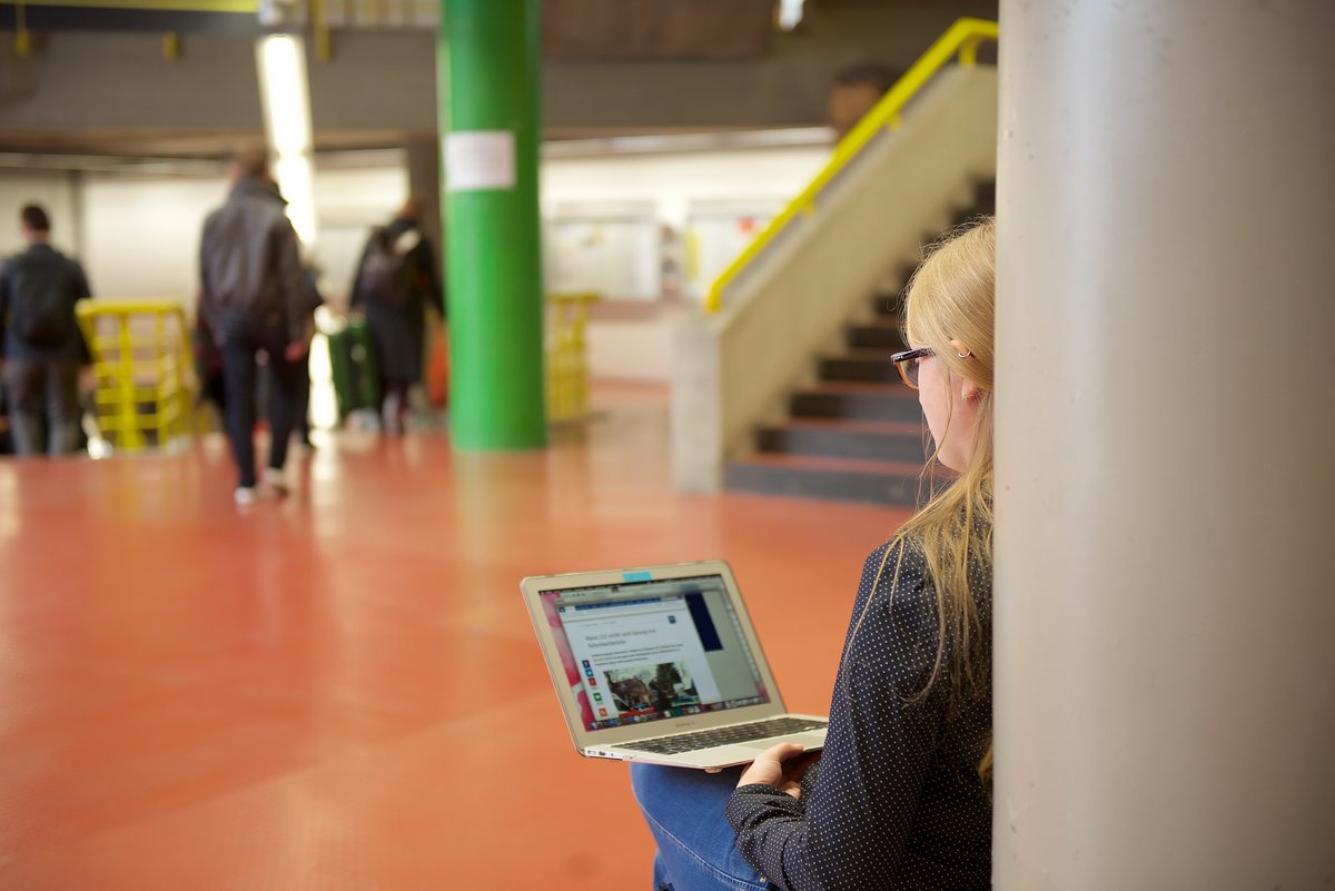 Studentin mit Laptop im Hauptgebäude